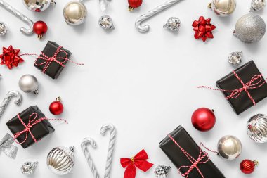 Noel balolarından yapılmış çerçeve hediye kutuları ve beyaz arka planda şeker kamışları