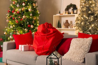 Noel için dekore edilmiş oturma odasının içinde Noel Baba çantası ve kanepe.