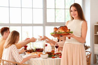 Şükran Günü 'nde hindiyle yemek yiyen genç kadın.