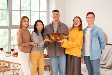 Şükran Günü 'nde hindi yiyen bir grup genç arkadaş.