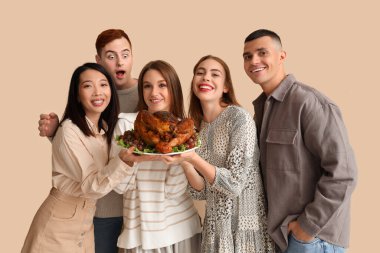 Bej arka planda lezzetli hindi olan bir grup genç arkadaş. Şükran Günü kutlaması