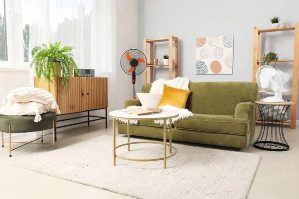 Interior of stylish living room with electric fans and sofa