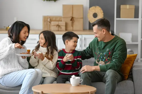 Happy family drinking milk with cookies at home on Christmas eve