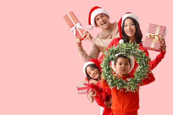 Glückliche Familie Mit Weihnachtskranz Und Geschenken Auf Rosa Hintergrund — Stockfoto