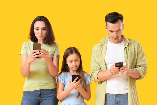 Involved family with mobile phones on yellow background