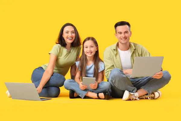 Familia Feliz Sentado Suelo Con Gadgets Sobre Fondo Amarillo — Foto de Stock