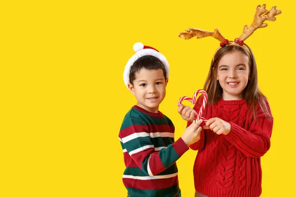 Niedliche Kleine Kinder Mit Zuckerstangen Auf Gelbem Hintergrund — Stockfoto