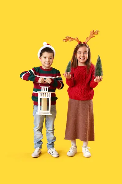 Niedliche Kleine Kinder Mit Laterne Und Spielzeug Weihnachtsbäume Auf Gelbem — Stockfoto