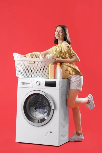 Jovem Com Cesta Roupa Máquina Lavar Roupa Fundo Vermelho — Fotografia de Stock