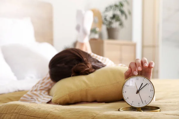 ベッドに横たわる目覚まし時計を持つ女性 クローズアップ — ストック写真
