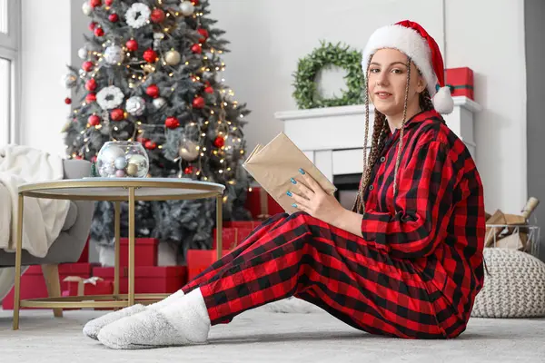 Young Woman Santa Hat Reading Book Home Christmas Eve — Stock Photo, Image