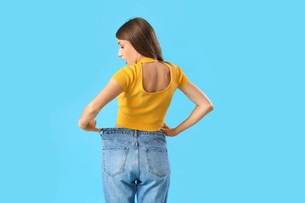Mulher Bonita Jeans Soltos Fundo Azul Visão Traseira Conceito Perda — Fotografia de Stock