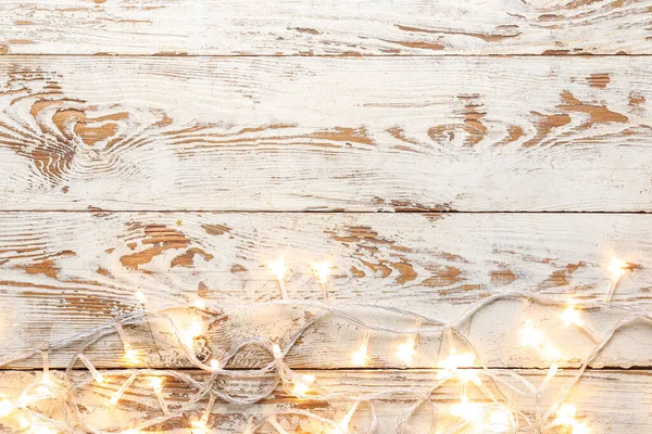 Beyaz ahşap arka planda parlayan Noel ışıkları