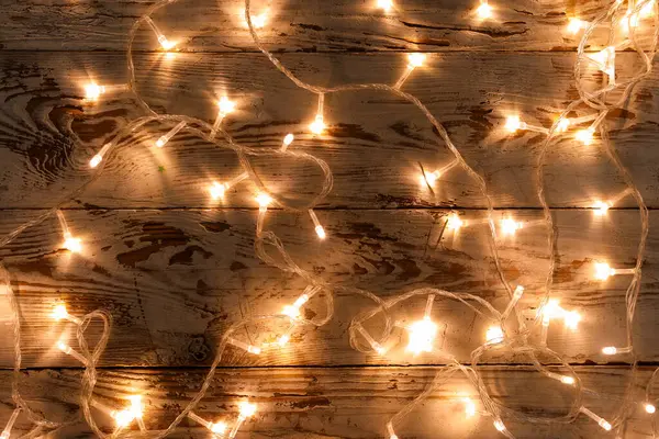 Koyu ahşap arka planda parlayan Noel ışıkları