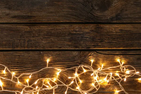 Ahşap arka planda parlayan Noel ışıkları