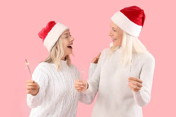 Glückliche Tochter Und Ihre Mutter Weihnachtsmützen Mit Wunderkerzen Auf Rosa — Stockfoto