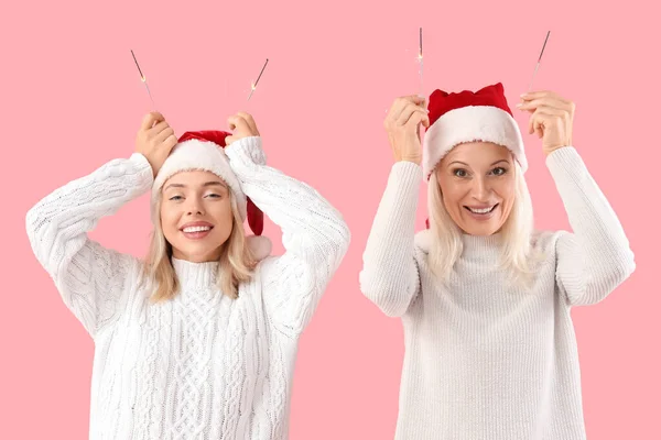 Happy Daughter Her Mother Santa Hats Sparklers Pink Background — Stock Photo, Image