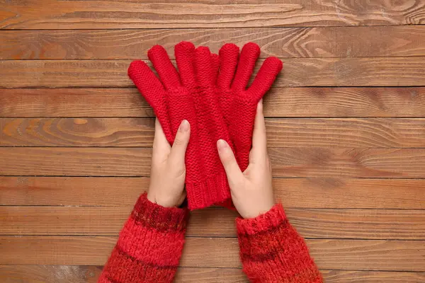Weibliche Hände Mit Warmen Handschuhen Auf Hölzernem Hintergrund Nahaufnahme — Stockfoto