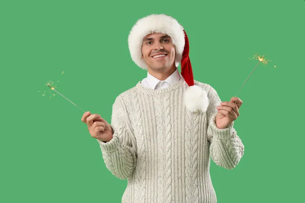 Happy Young Man Santa Hat Sparklers Green Background — Stock Photo, Image