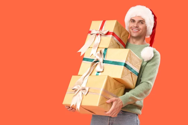 Happy Young Man Santa Hat Gift Boxes Orange Background — Stock Photo, Image