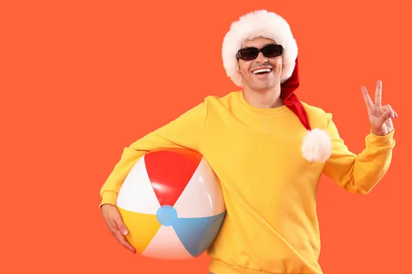 Happy Young Man Santa Hat Inflatable Ball Showing Victory Gesture — Stock Photo, Image