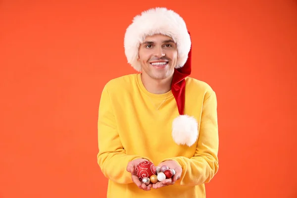 Happy Young Man Santa Hat Christmas Balls Orange Background — Stock Photo, Image