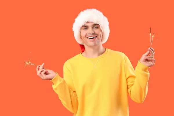 Happy Young Man Santa Hat Sparklers Orange Background — Stock Photo, Image