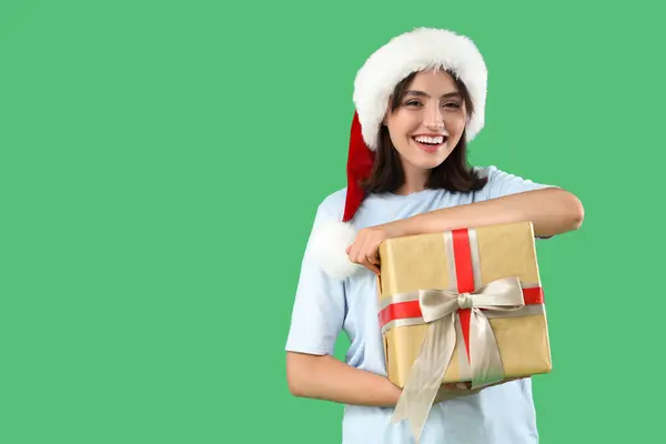 美しい幸せな若い女性 サンタの帽子で緑の背景にギフトボックス — ストック写真
