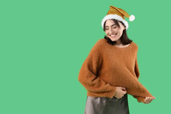 Yeşil Arka Planda Noel Baba Şapkalı Güzel Bir Kadın — Stok fotoğraf