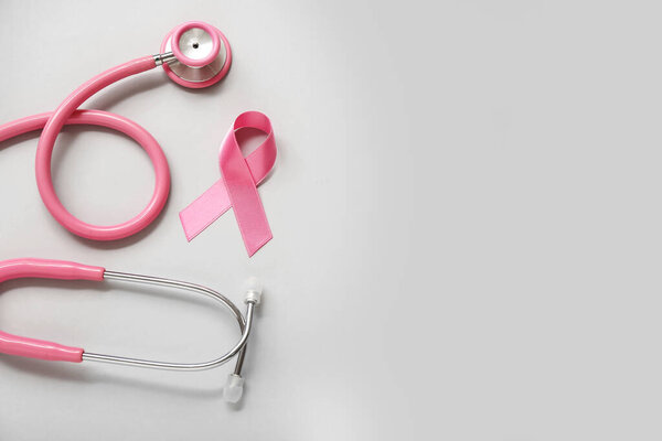 Pink ribbon with stethoscope on grey background. Breast cancer awareness concept