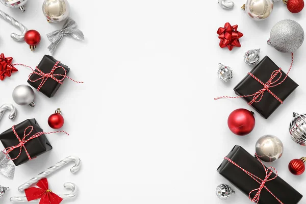 Hediye kutularıyla Noel baloları ve beyaz arka planda şeker kamışları.