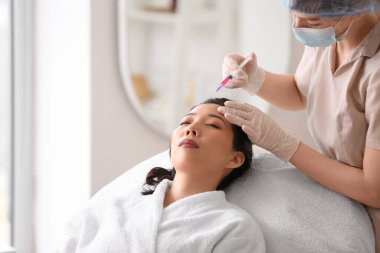 Genç Asyalı kadın güzellik salonunda iğne oluyor. Cilt bakımı kavramı