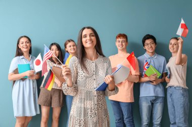 Mavi arka planda bayrakları olan dil okulunun genç öğrencileri