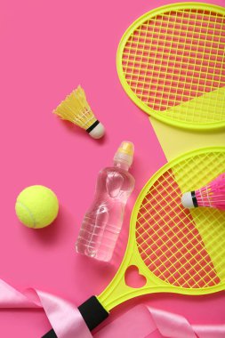 Renkli arka planda su şişesi ve farklı spor ekipmanlarıyla kompozisyon