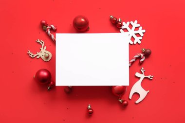 Noel topları, kar taneleri ve kırmızı arka planda şeker kamışları olan boş kart.
