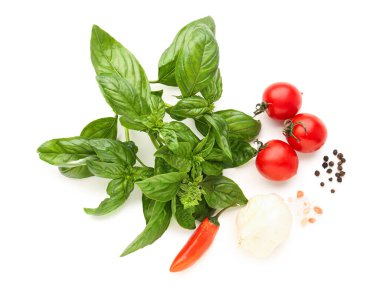 Taze fesleğen, kiraz domatesleri ve beyaz arka planda biber.