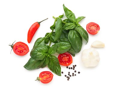 Taze fesleğen, kiraz domatesleri ve beyaz arka planda biber.