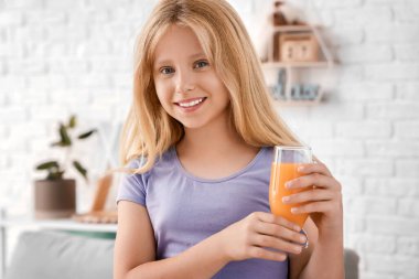 Evde bir bardak meyve suyu ile küçük bir kız