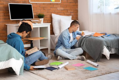 Yurt odasında ödev yapan erkek öğrenciler