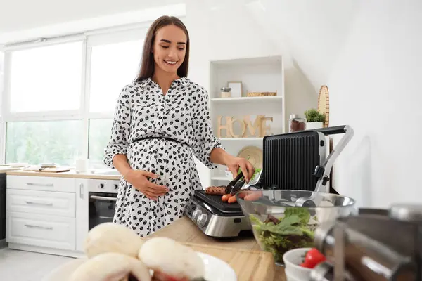 Beautiful Young Pregnant Woman Cooking Sausages Modern Electric Grill Kitchen — Stock Photo, Image