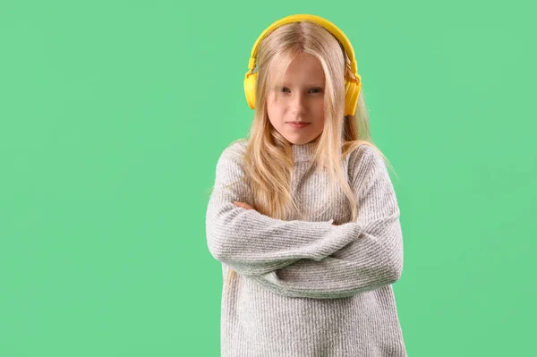Yeşil Arka Planda Kulaklık Takan Üzgün Küçük Kız — Stok fotoğraf