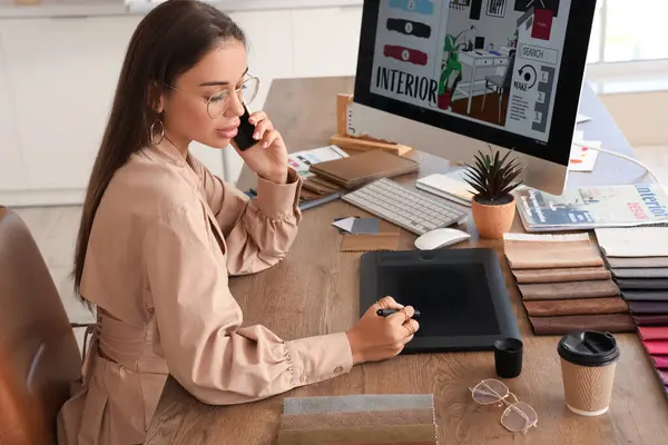 Female interior designer working with graphic tablet at table in office