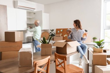 Taşınırken mutfakta bavulları boşaltan genç bir çift.