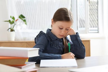 küçük kız evde ders yapıyor