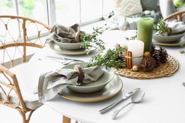 Yanan mumlar ve kozalaklarla Noel sofrası.