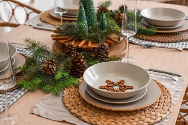 Köknar dalları ve çam kozalakları ile Noel sofrası