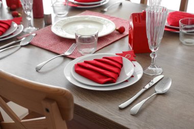 Kırmızı katlanmış peçeteler ve Noel dekoruyla şenlik masası.