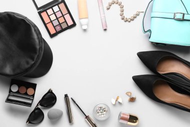 Açık arkaplanda şık kadın aksesuarları, ayakkabıları ve kozmetik ürünlerinden yapılmış çerçeve