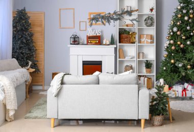 Beyaz kanepeli ve Noel dekorlu festival salonu.