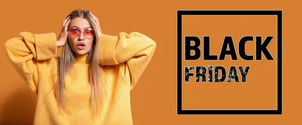 Surprised young woman and text BLACK FRIDAY on orange background